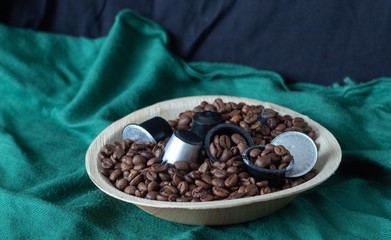 bowl of coffee beans and coffee capsules