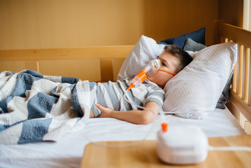 A young boy is given an inhalation during a lung disease. Medicine and care