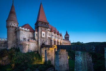 Fototapeta na wymiar Corvin Castle at twilight, or Hunyadi Castle, one of Seven wonders of Romania. Large, medieval Gothic-Renaissance building. Hunedoara, Romania