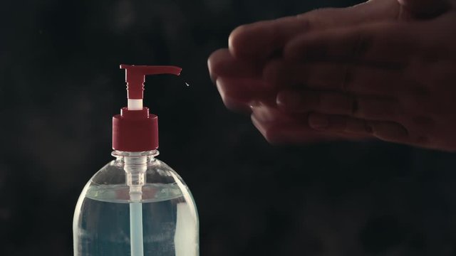 Hand sanitizer or sanitiser gel for clean hands from coronavirus. Male hands using antibacterial washing protection gel