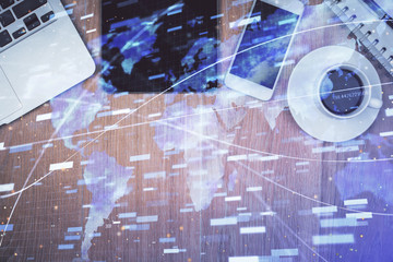 Double exposure of technology theme drawing over work table desktop. Top view. Global data analysis concept.
