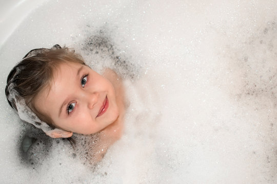 Sweet little girl in the bath foam