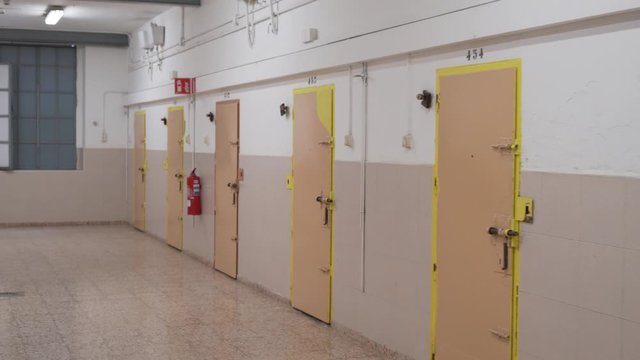 camcorder moves slowly along the closed doors of the prison cells