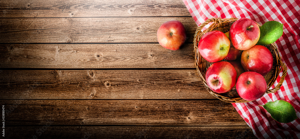 Wall mural ripe red apples in wooden box top view on rustic table. wide apple banner with space for your text