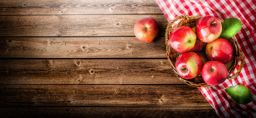 Obraz na płótnie Canvas Ripe red apples in wooden box top view on rustic table. Wide apple banner with space for your text