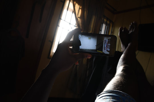 Young Black Male Watching A Movie On His Phone While Indoors