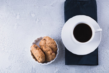 White cup of coffee with oatmeal cookies and coffee maker, breakfast concept, selective focus