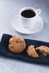 White cup of coffee with oatmeal cookies and coffee maker, breakfast concept, selective focus