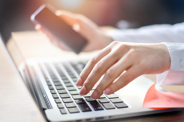 business woman working on laptop computer on wooden desk as concept with social media success technology.