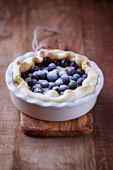 Blueberry Quiche ina Ceramic Dish on rustic wooden background.	