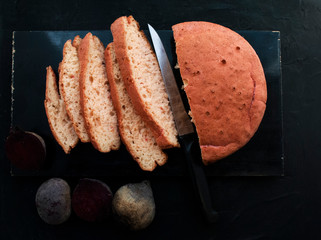 Gluten free food. Homemade rice flour bread with beetroot juice. Pink bread on a black background.