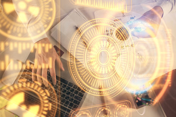 Double exposure of man's hands typing over computer keyboard and tech theme hologram drawing. Top view. Technology concept.