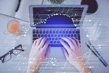 Multi exposure of man's hands typing over computer keyboard and data theme hologram drawing. Top view. Technology concept.
