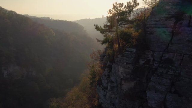 Aerial flight closely to rocks in autumn at sunset in Krasnaya Polyana, Sochi