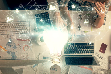Double exposure of man and woman working together and bulb drawing. Computer background. Top View. Idea concept.