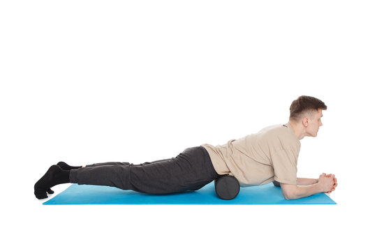 Handsome man shows exercises using a foam roller
