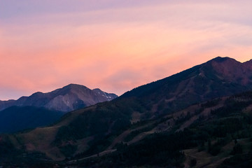 Naklejka na ściany i meble Pink orange sunset in Aspen, Colorado with rocky mountains peak in autumn and vibrant pastel color at twilight