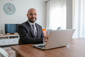 Confident businessman with beard in suit doing job interview with leptop at home.