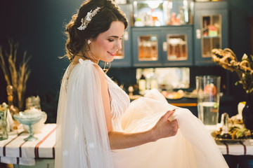 Attractive young bride before wedding ceremony. Bride's Preparations. Wedding Morning. Charming bride in white wedding dress at home. Beautiful bride is waiting her groom