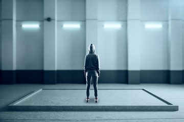 Fototapeta premium Back view of hacker abstract illuminated concrete interior