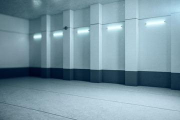 Modern illuminated concrete interior with empty copyspace on wall.