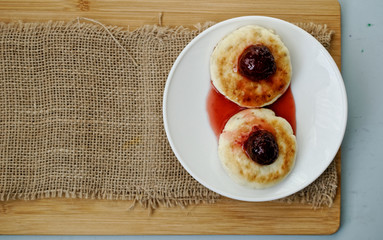 curd pancake on a white plate with strawberry jam. top view.
