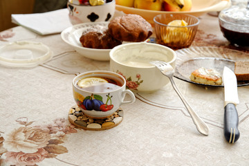 a dining table in the village. on the table is sour cream, apples, bananas, pies with sweets, curd pancake.