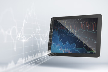 Close up of digital tablet with stock chart hologram.