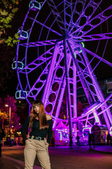 woman in amusement park with ferris wheel