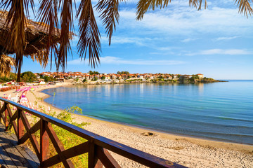 Seaside landscape - view from the cafe to the sandy beach with umbrellas and sun loungers in the town of Sozopol on the Black Sea coast in Bulgaria