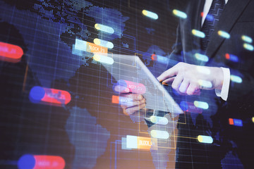 Double exposure of man's hand holding and using a digital device and data theme hologram drawing. Technology concept.