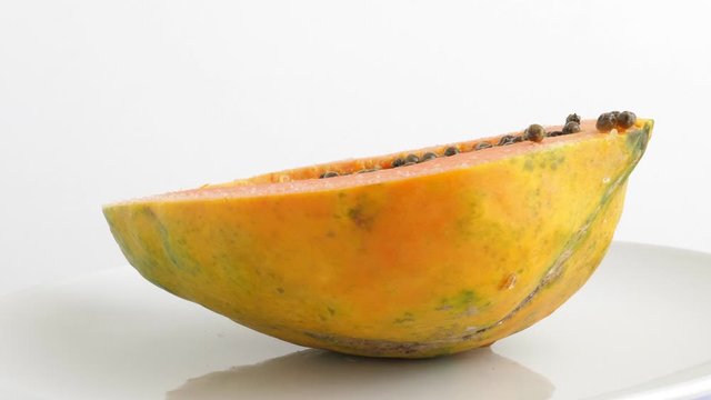 Ripe half cut papaya. Rotating on white background