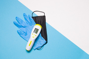 blue disposable medical glove, black face mask, infrared thermometer for non-contact temperature...