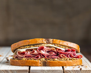 Ham and swiss sandwich on wooden surface