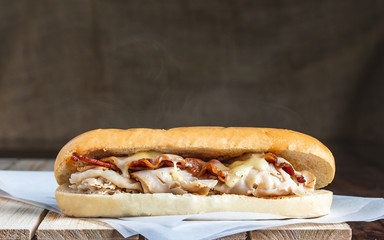 Bacon and turkey sandwich with melted cheese and steam