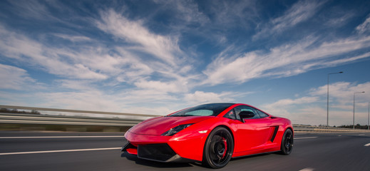 Red cabriolet parking under the blue sky