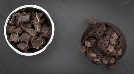 Fresh made Chocolate Muffins on a slate slab (close-up shot; selective focus)