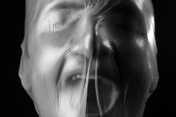 close-up portrait of a plastic bag on the face asphyxiation