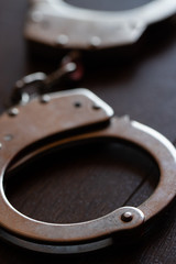 steel metal Handcuffs on brown background