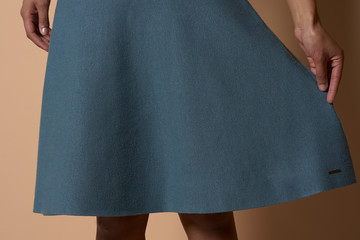 Woman holding her blue skirt wide