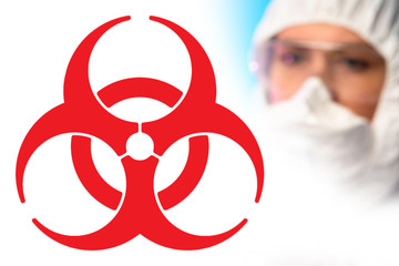 A large red biohazard sign and the face of a chemist in a protective mask. Medical quarantine. Security measures during quarantine. Preventing the spread of the disease. Epidemic. - obrazy, fototapety, plakaty
