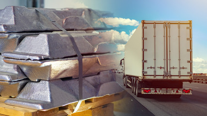 Aluminum close-up and a truck on the road. Raw materials for the automotive industry. Automobile transportation of aluminum. Transportation of non-ferrous metals.