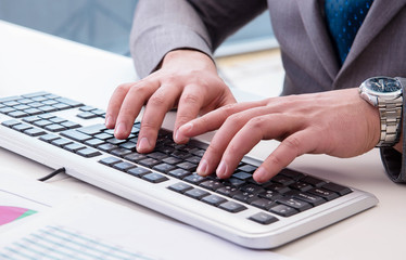 Finance professional working on keyboard with reports