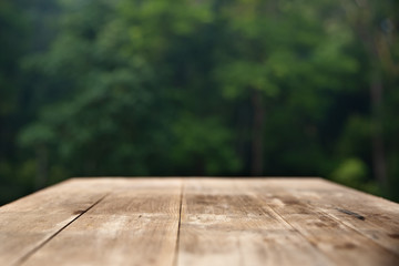 Brown wood table top on a green blur abstract background