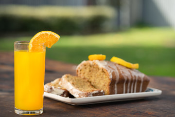Cup of Dalgona coffee served on a glass with a bar of chocolate and a wholemeal cake. Outdoor background