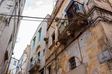 Fototapeta na wymiar Old town street view in Altamura, Apulia, Italy. Via Mario Tirelli or Mario Tirelli Street partial low-angle high section view with decoration