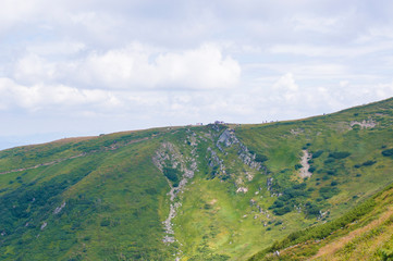 mountain slopes in with green meadow