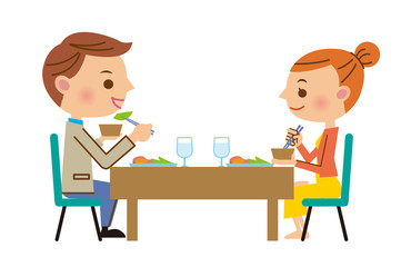 テーブルで食事をしながら話す男女