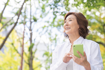 シニア女性　外出　スマホ