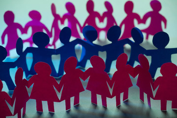 Obraz premium Paper dolls holding hands symbolizing union and team
